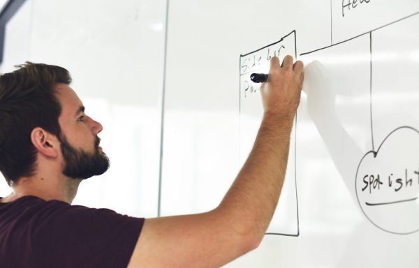 adult writing on a white board