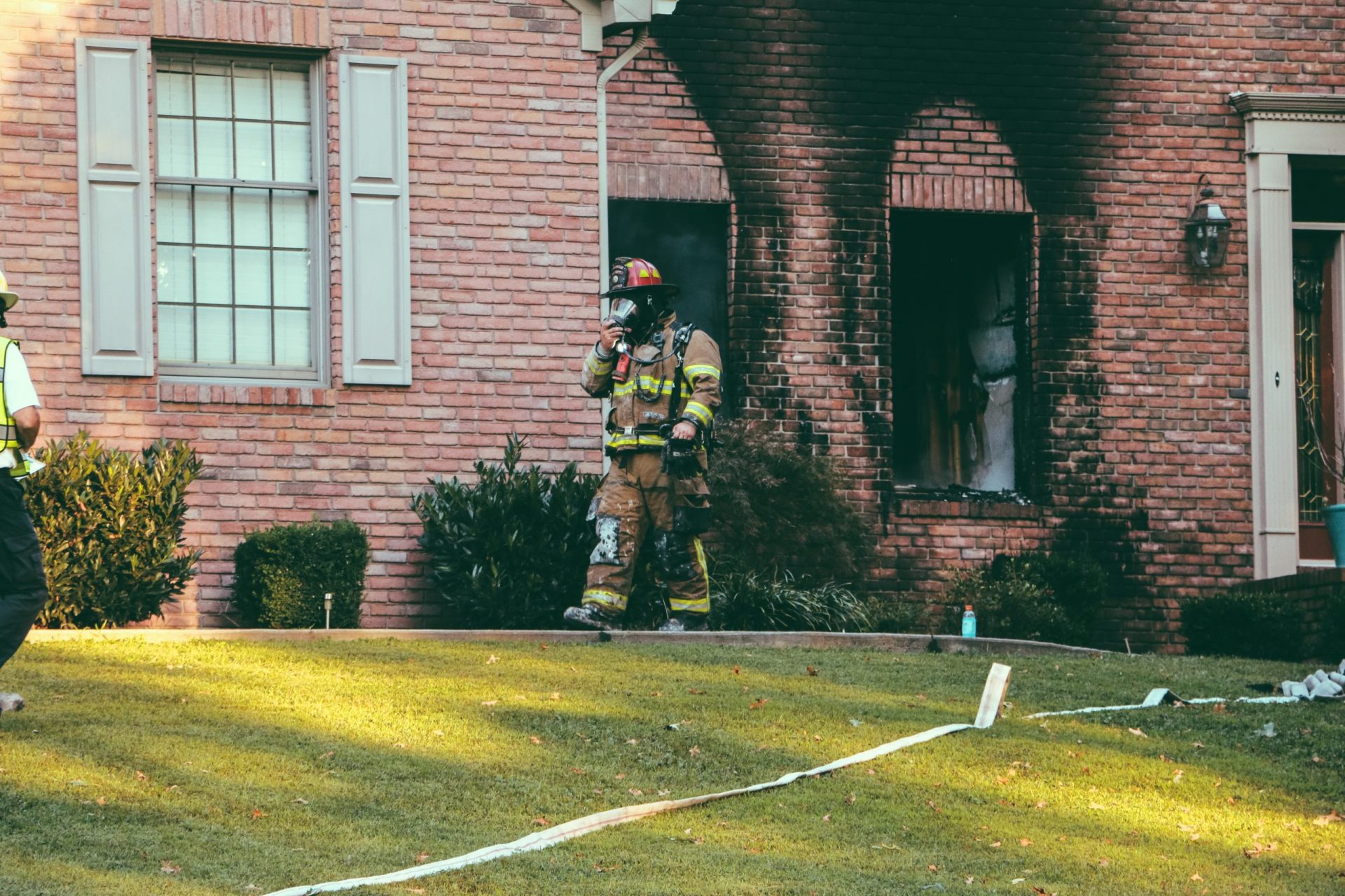 Firefighter walking out of a house