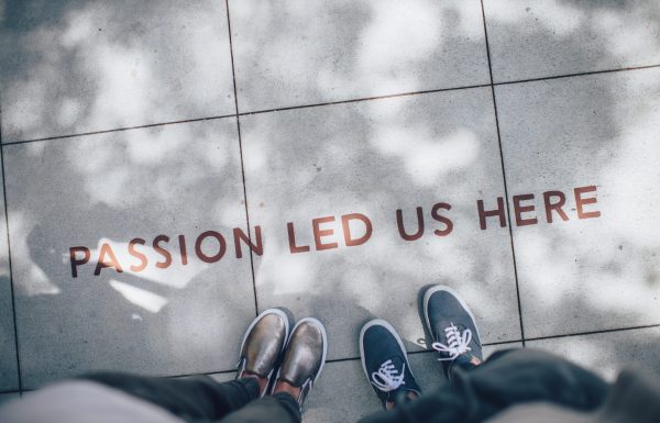 feet standing over "PASSION LED US HERE"