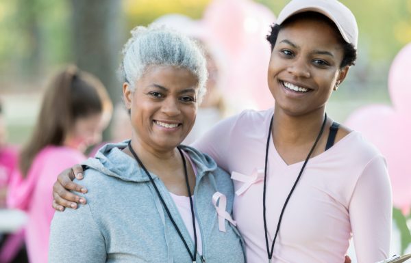 Senior woman and daughter smile for camera at race for cure