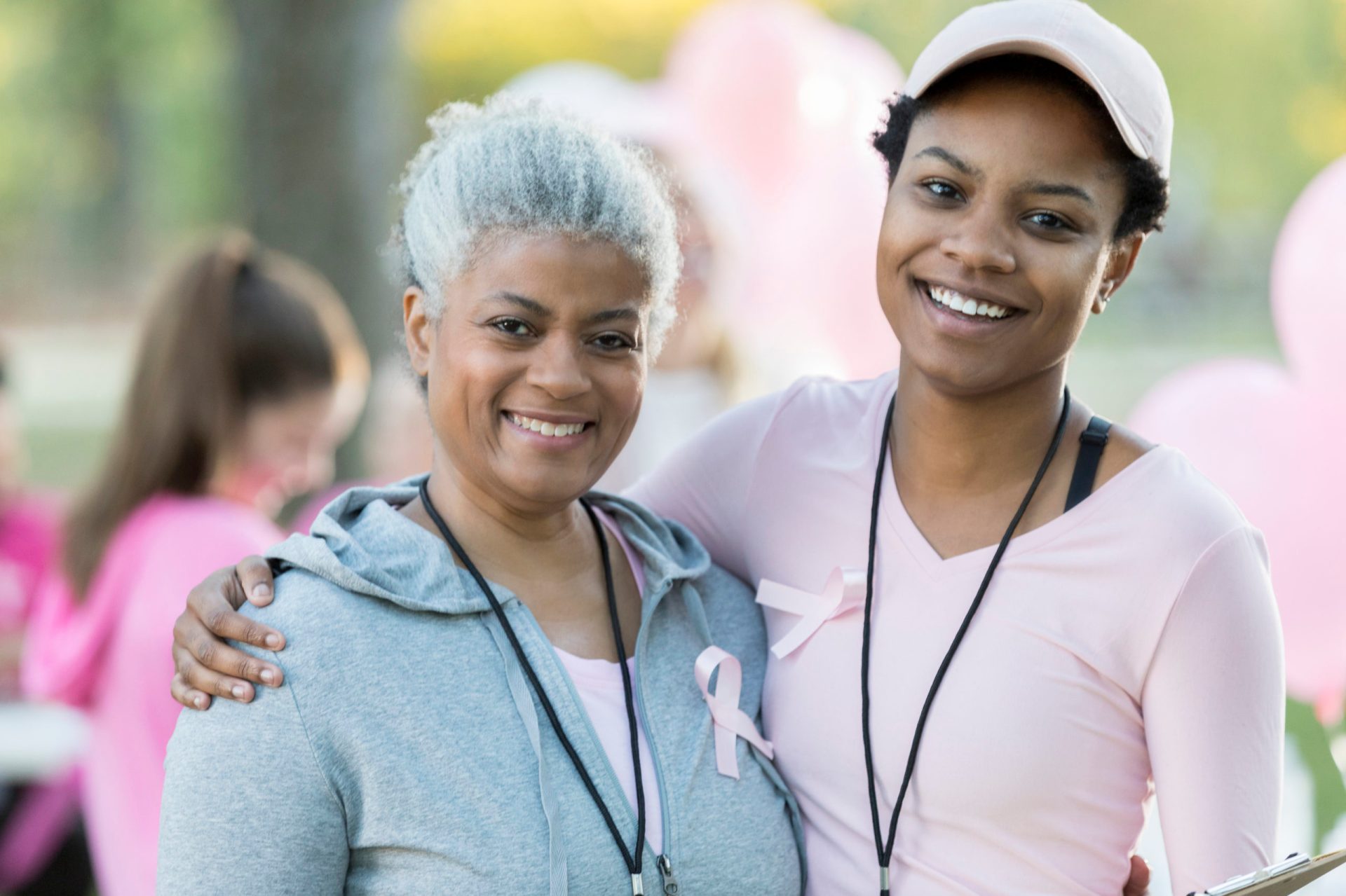 Senior woman and daughter smile for camera at race for cure