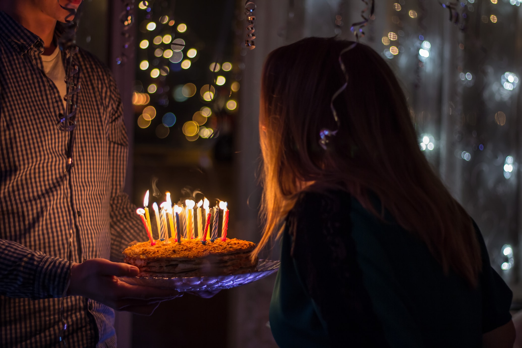 Person blowing out candles on a birthday cake