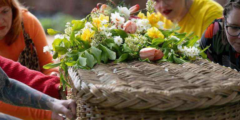 Friends and family holding a casket with flowers