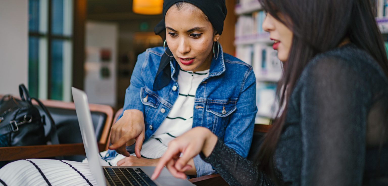 Two women working on a laptop