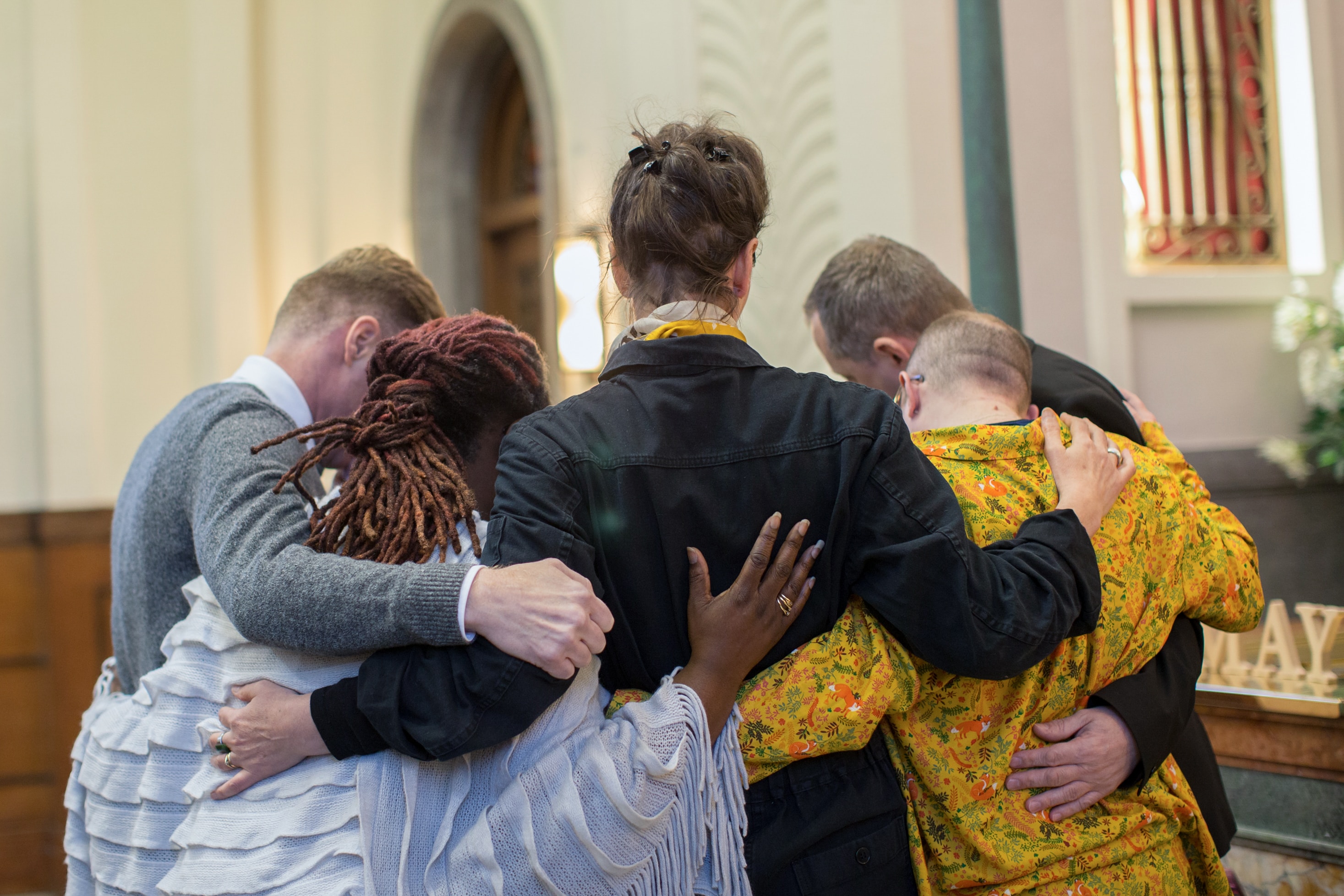 A group of people hugging at a funeral service