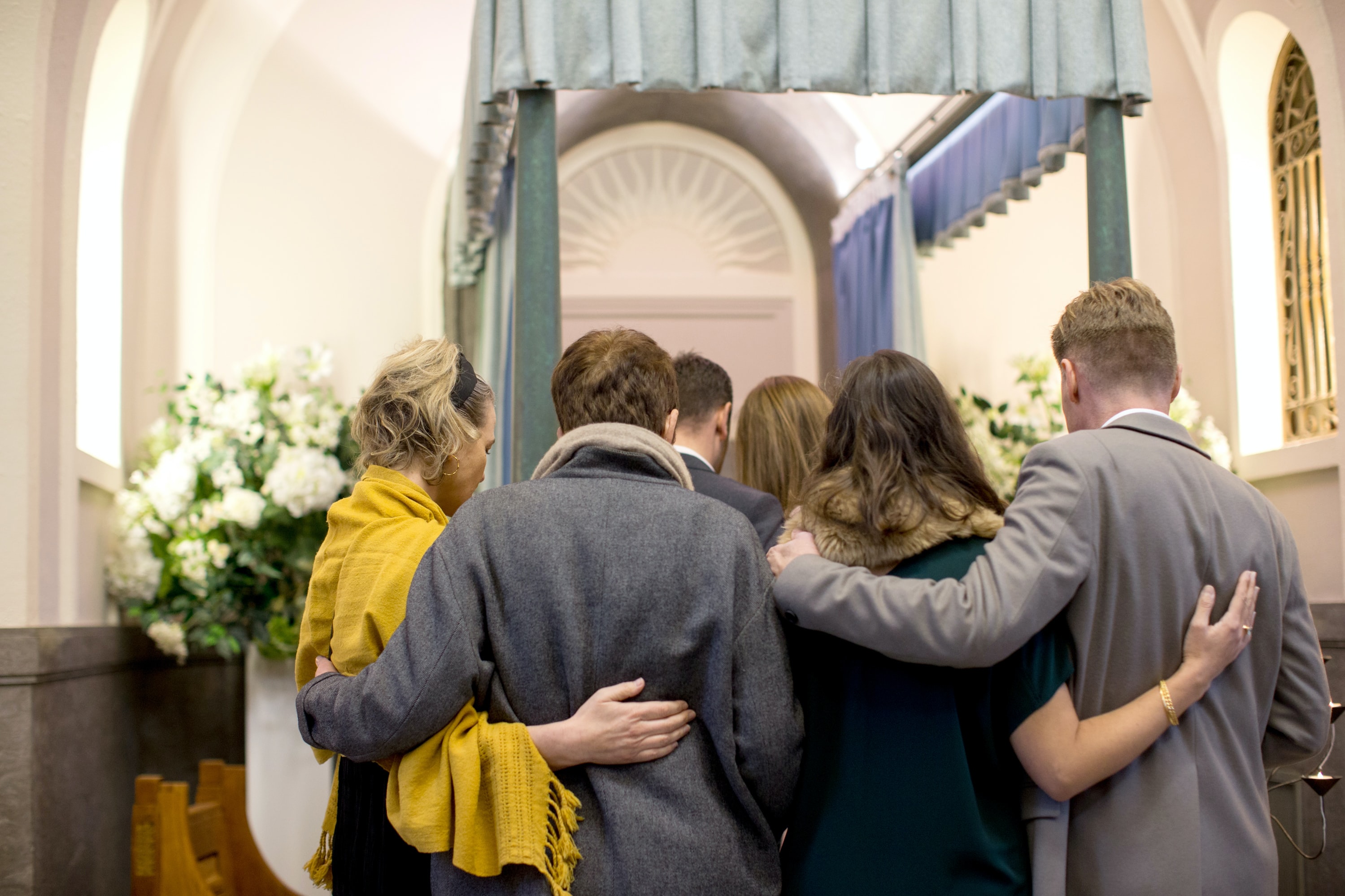 Group of people hugging at a funeral
