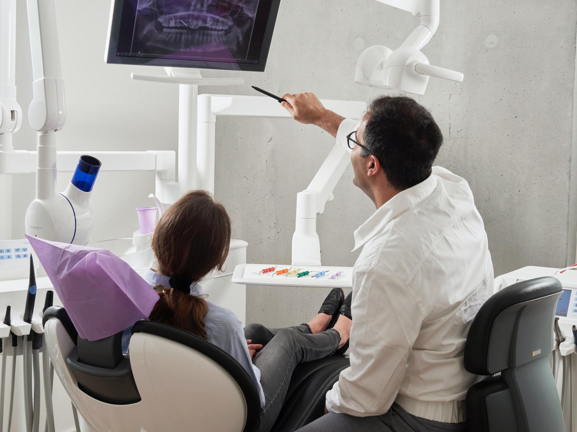 A dentist reviews charts with a patient