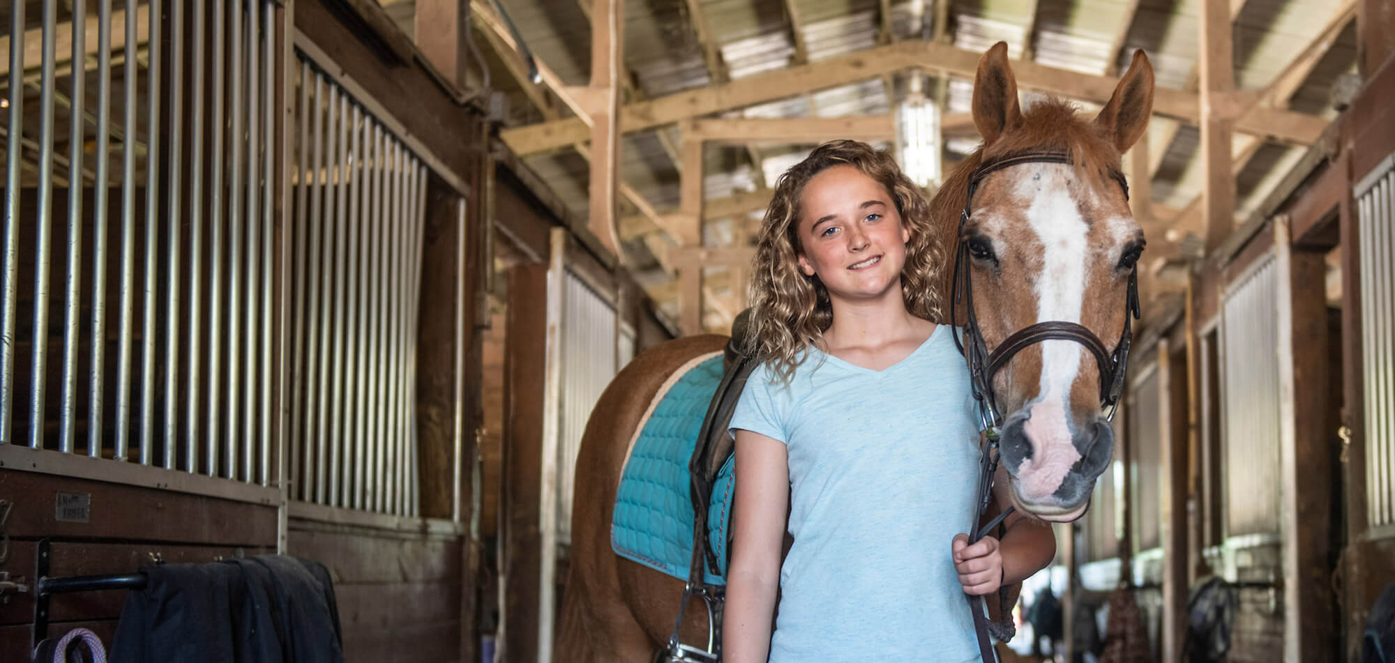 Young girl holding the reigns of a horse