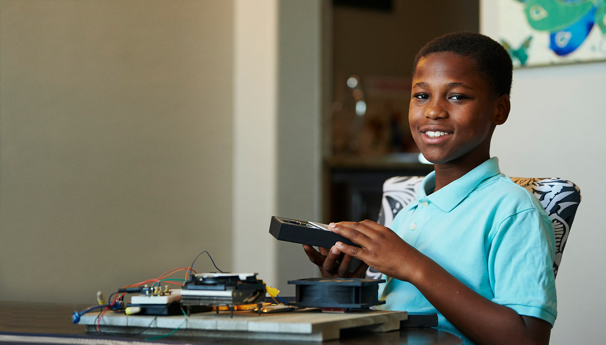 Young boy smiling and holding an object