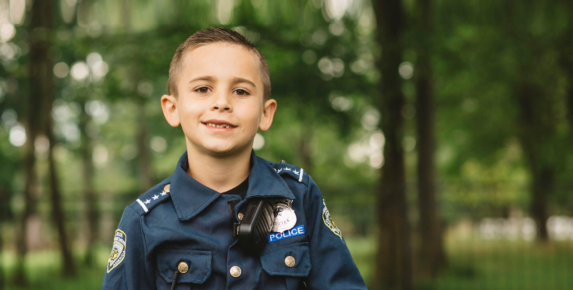 Little boy wearing a police costume and smiling