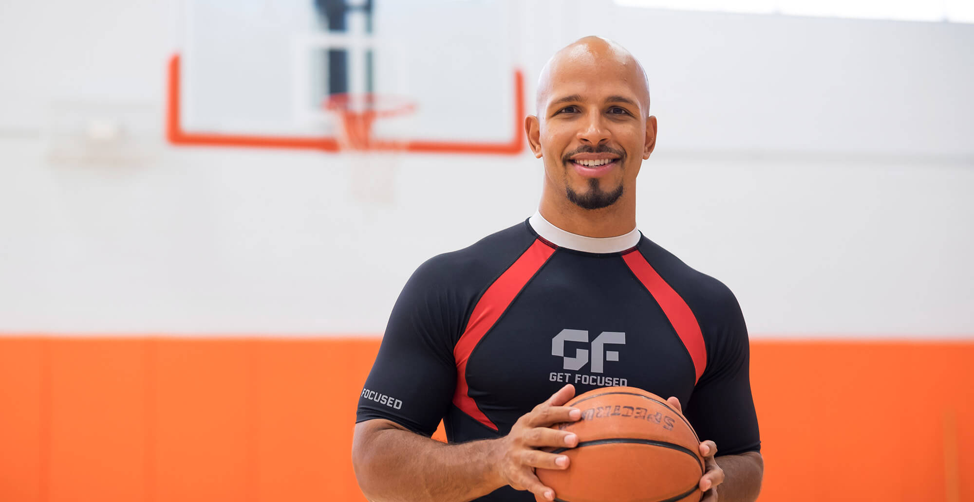 Man smiling and holding basketball
