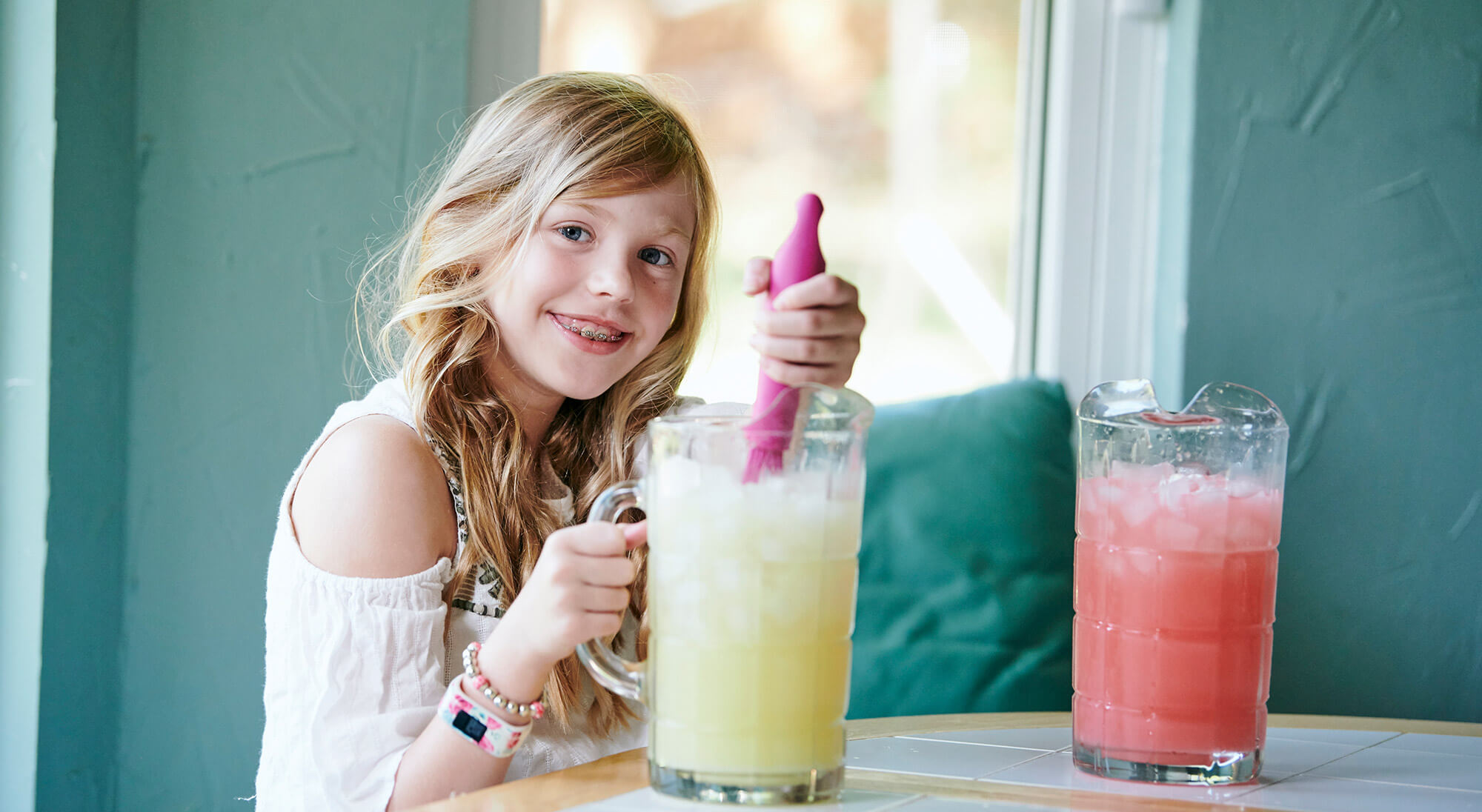 Young girl smiling while making lemonade