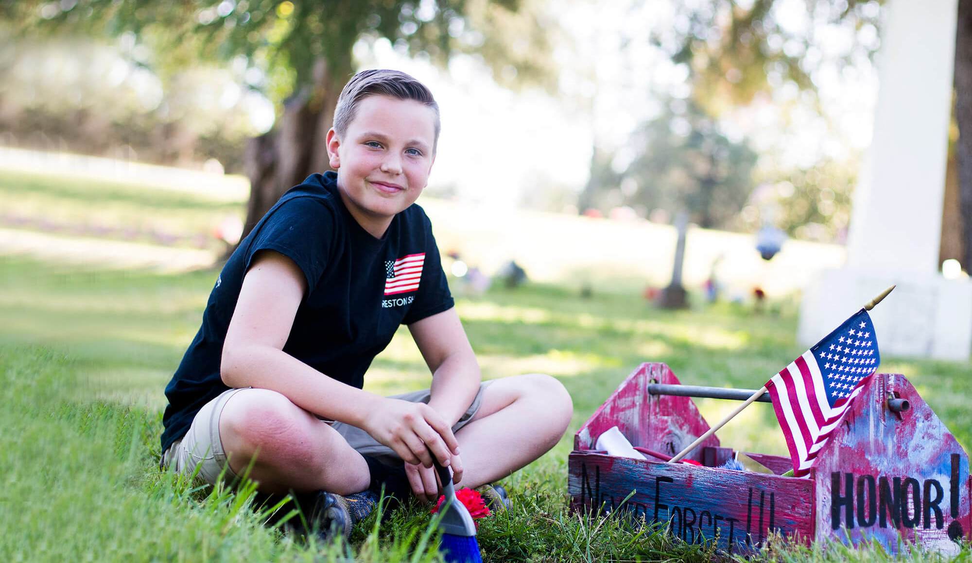 Boy smiling and sitting in the grass