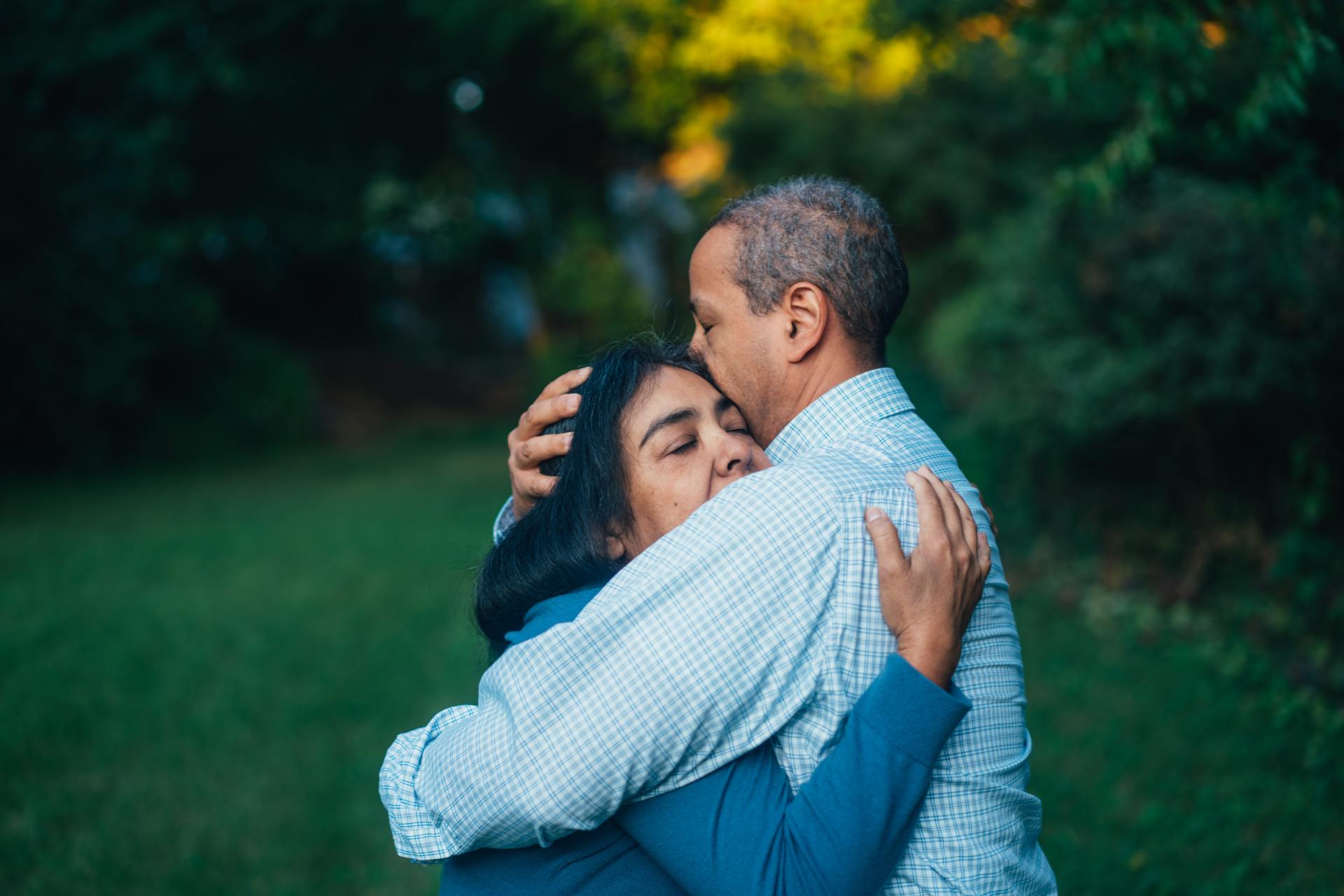 Two people hugging each other outside
