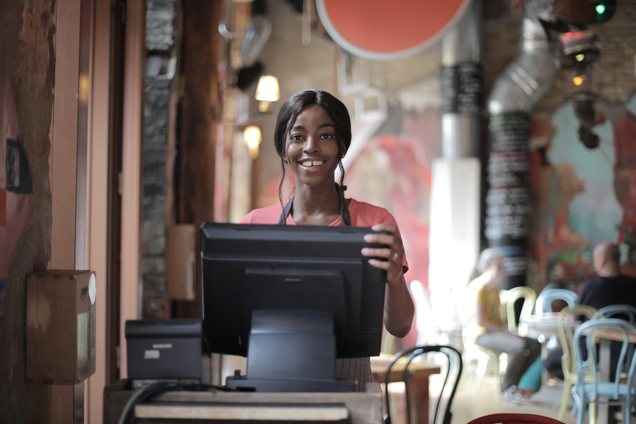 Cheerful-black-waitress-standing-at-counter1