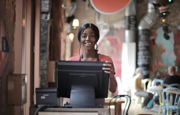 Cheerful-black-waitress-standing-at-counter1