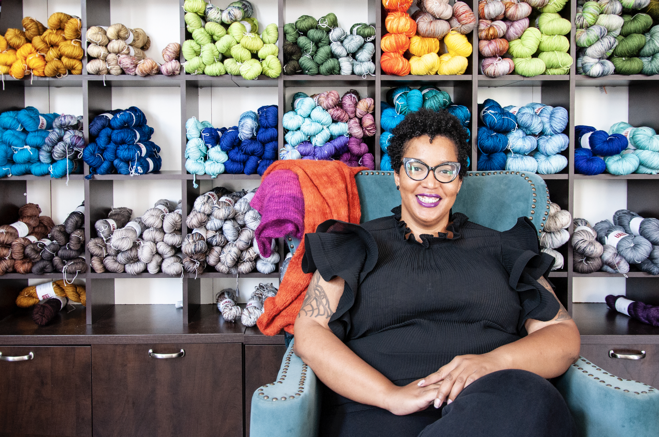 Karida Collins sitting in front of yarn