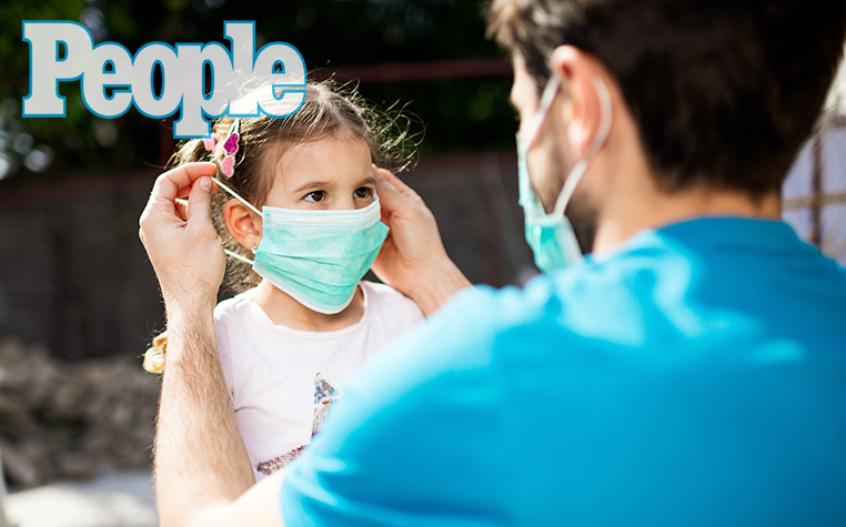 Single father applying pollution mask to his daughter