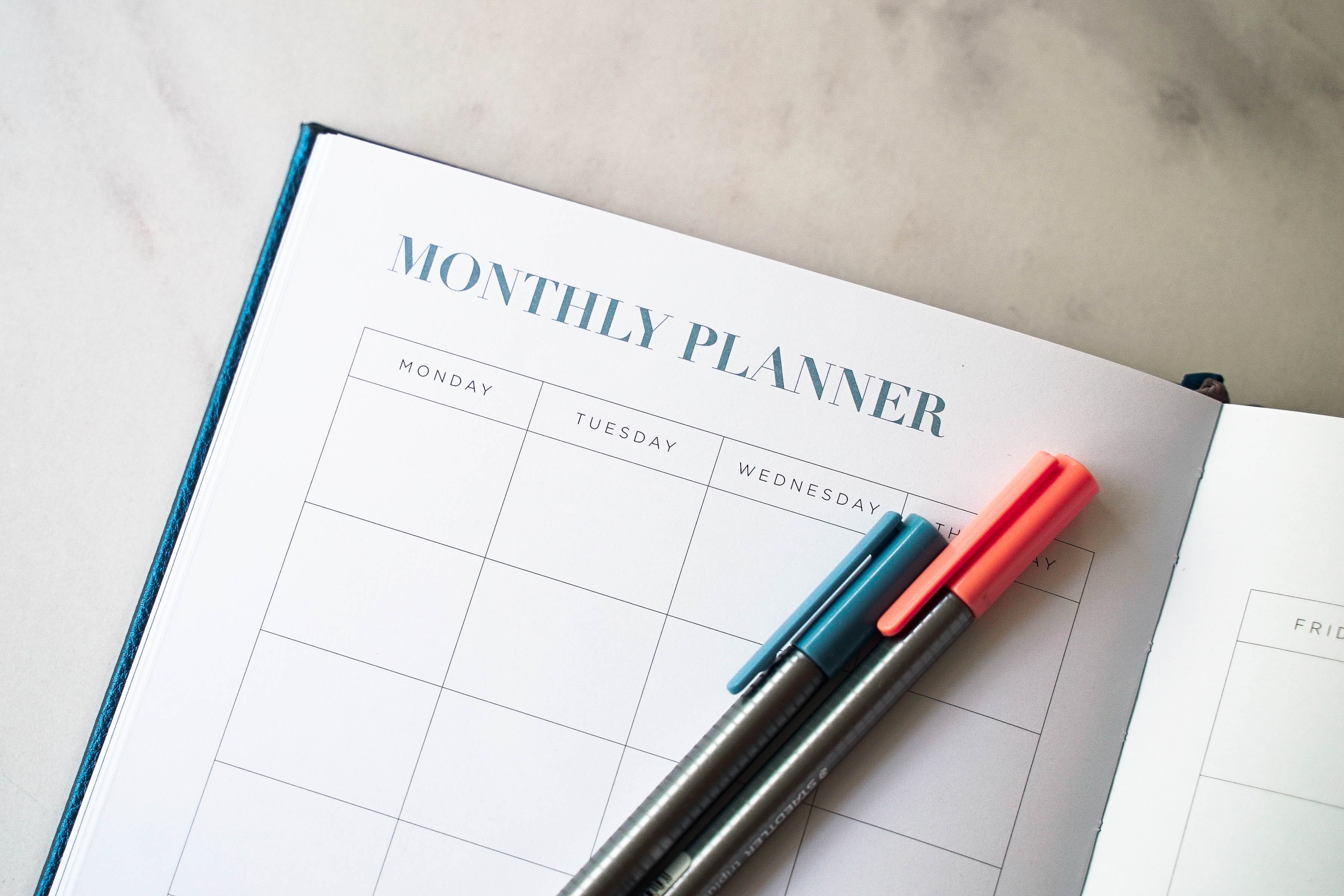 A monthly planner and two colored pens
