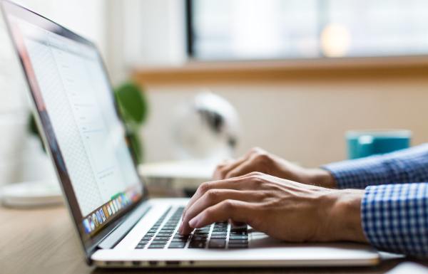 Person typing an email on a laptop