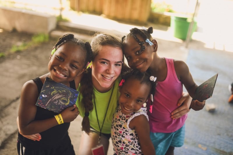 A person taking a picture with three kids