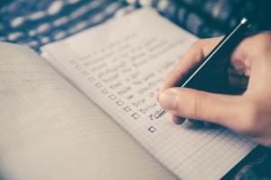 A person writing a list in a notebook