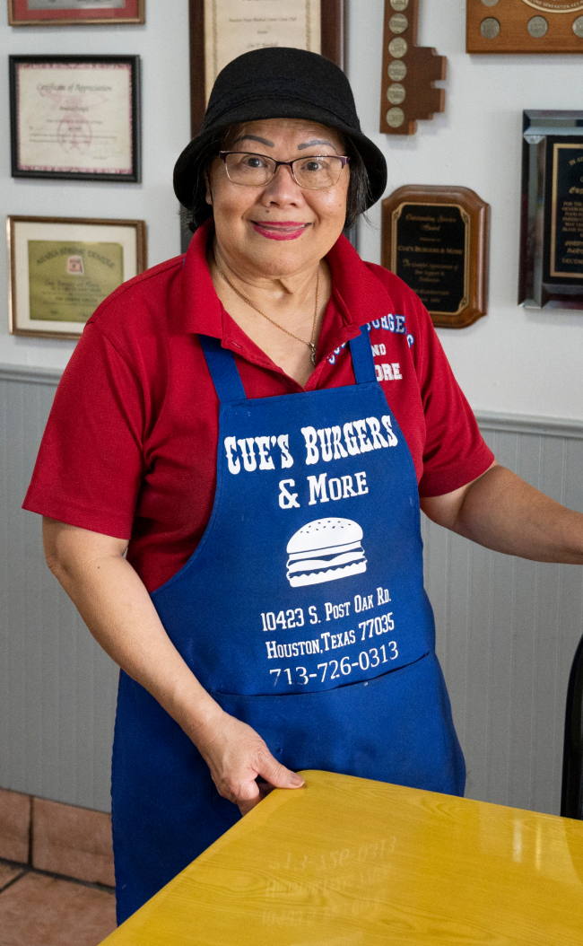 woman smiling while standing in her restaurant