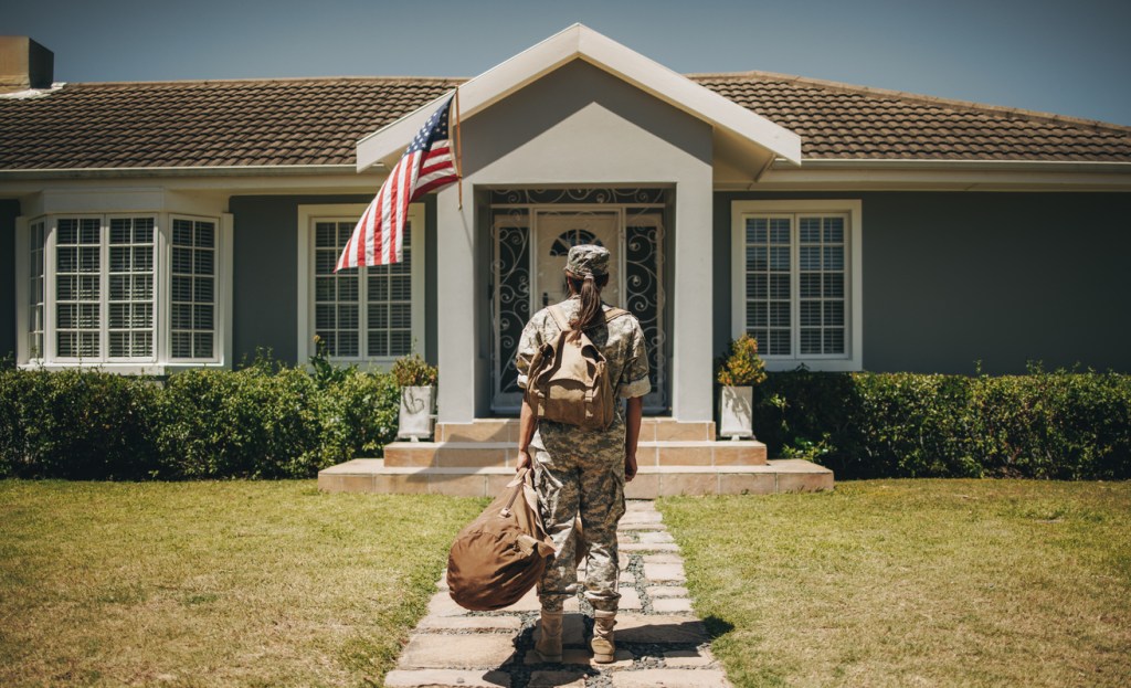 female veteran in front of her home