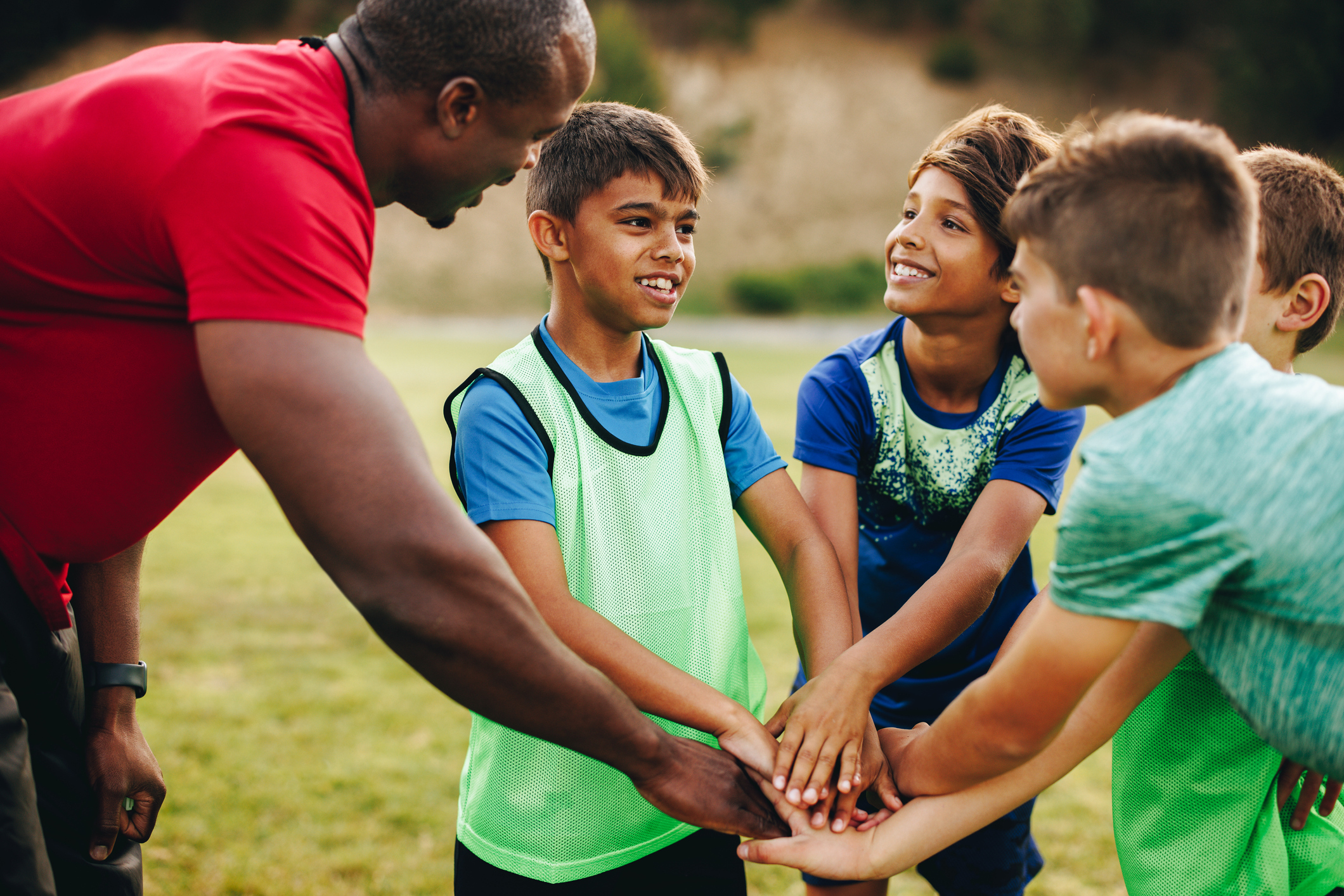 A coach and young athletes in a huddle