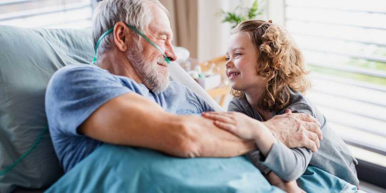 A grandfather smiling at his granddaughter