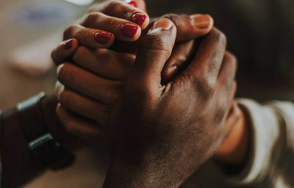Holding hands to comfort someone who is grieving