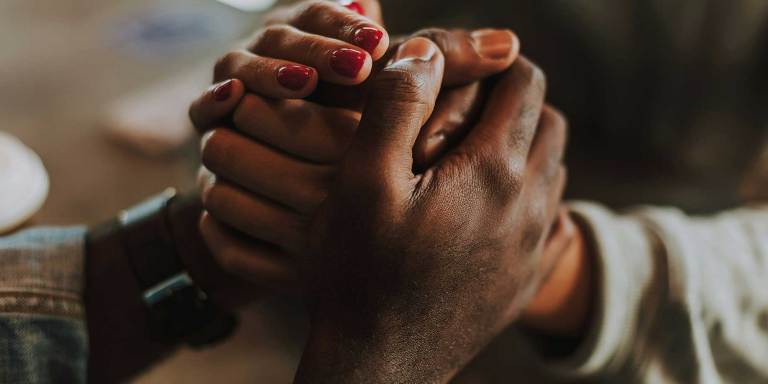 Holding hands to comfort someone who is grieving