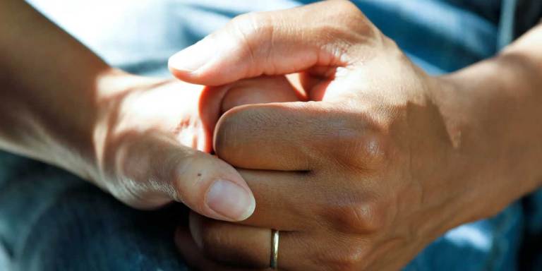 A person holding a cancer patient's hand