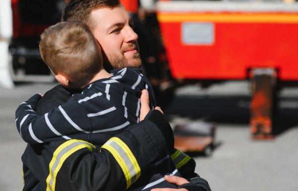 Firefighter hugging a boy
