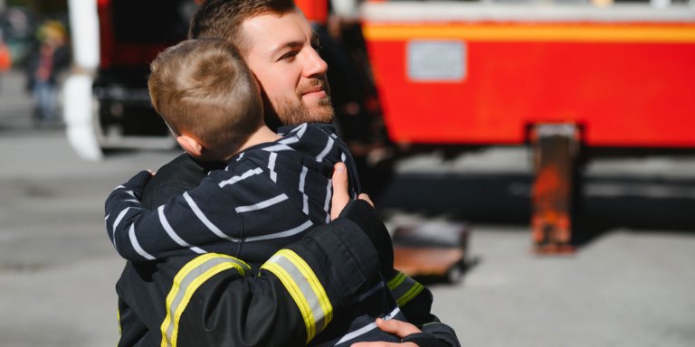 Firefighter hugging a boy