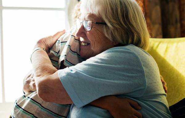 A grandmother being comforted by her grandson