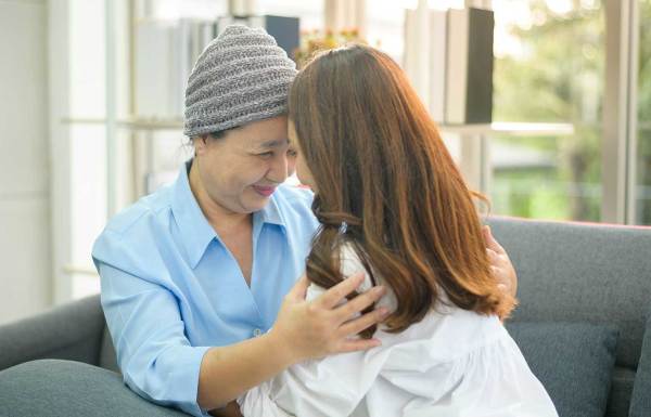 A cancer patient hugging a loved one