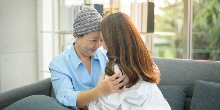 A cancer patient hugging a loved one