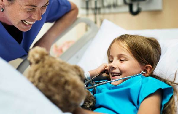 A surgeon smiling with a child patient