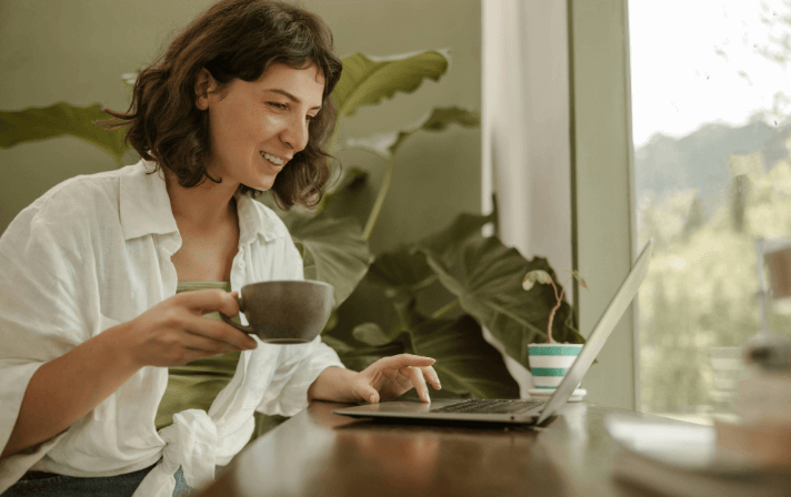 Woman working on her computer with a coffee