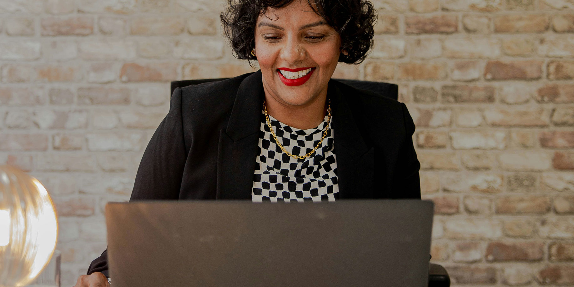 Woman smiling while working on a laptop