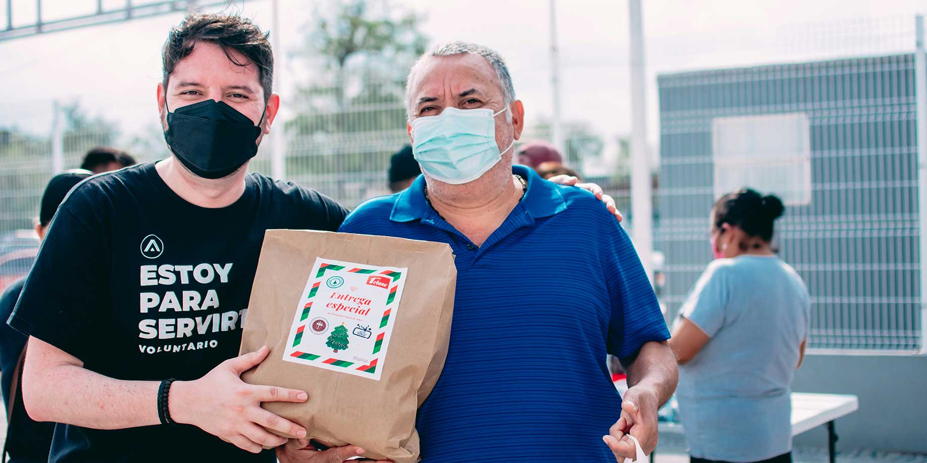 a volunteer handing a bag of donations to a community member