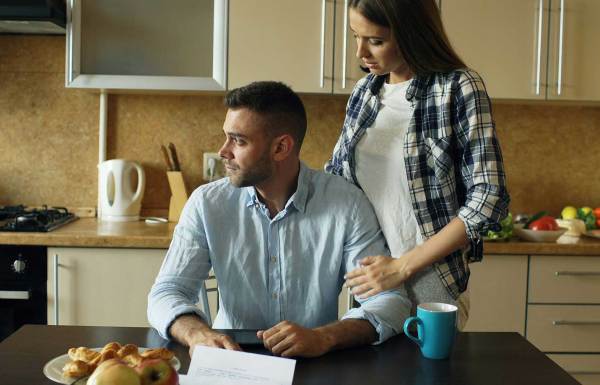 Couple looking over a bill at the kitchen table