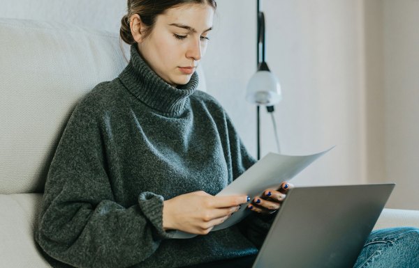 A woman looking at her charitable donation receipts with her laptop