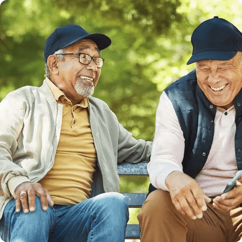 Friends laughing on a park bench together