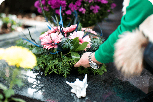 A person laying flowers on a grave