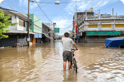 A person walking their bike through a flooded street