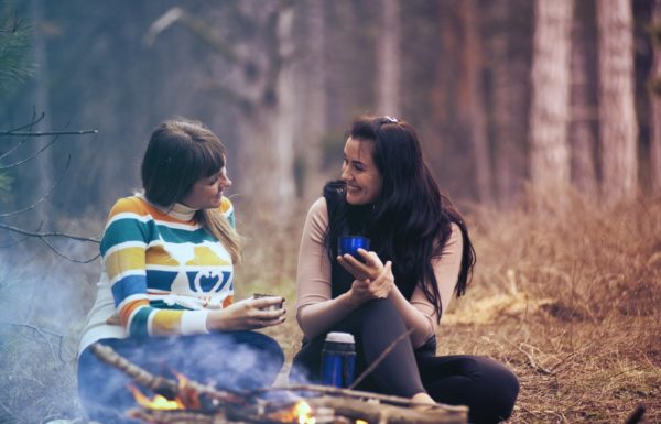 couple autour d'un feu dans la forêt