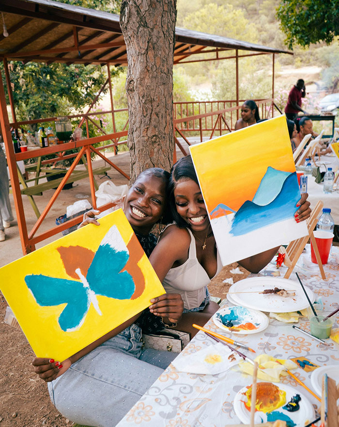 Two friends making art at a community event
