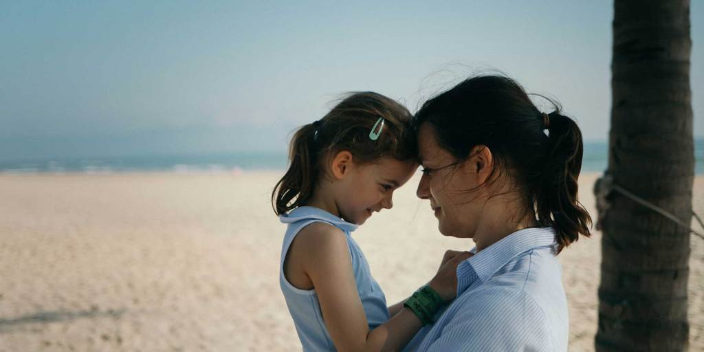 Single mother with her daughter at the beach